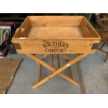 A WOODEN SOUTHERN COMFORT TRAY AND STAND