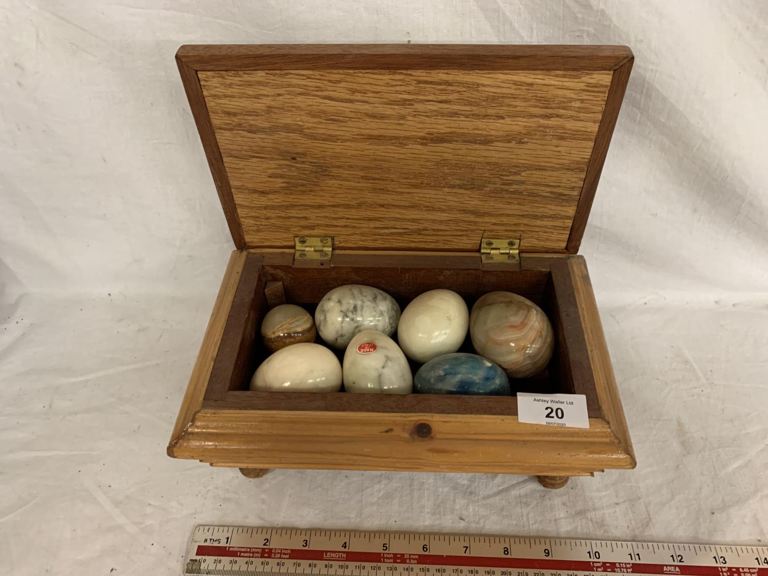 A WOODEN LIDDED BOX WITH SEVEN ONYX EGGS