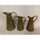 A SET OF THREE GRADUATED COPPER WATER JUGS BY JOSEPH SANKEY IN A CROCODILE PATTERN