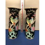 A PAIR OF CHINESE FAMILLE NOIRE CYLINDRICAL SLEEVE VASES (ONE A/F) 25 CM HIGH