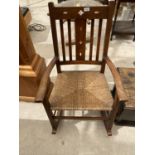 AN ARTS AND CRAFTS STYLE OAK ROCKING CHAIR WITH RUSH SEAT