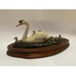 A BORDER FINE ARTS SWAN AND CYGNETS ON WOODEN PLINTH (AF TO NECK