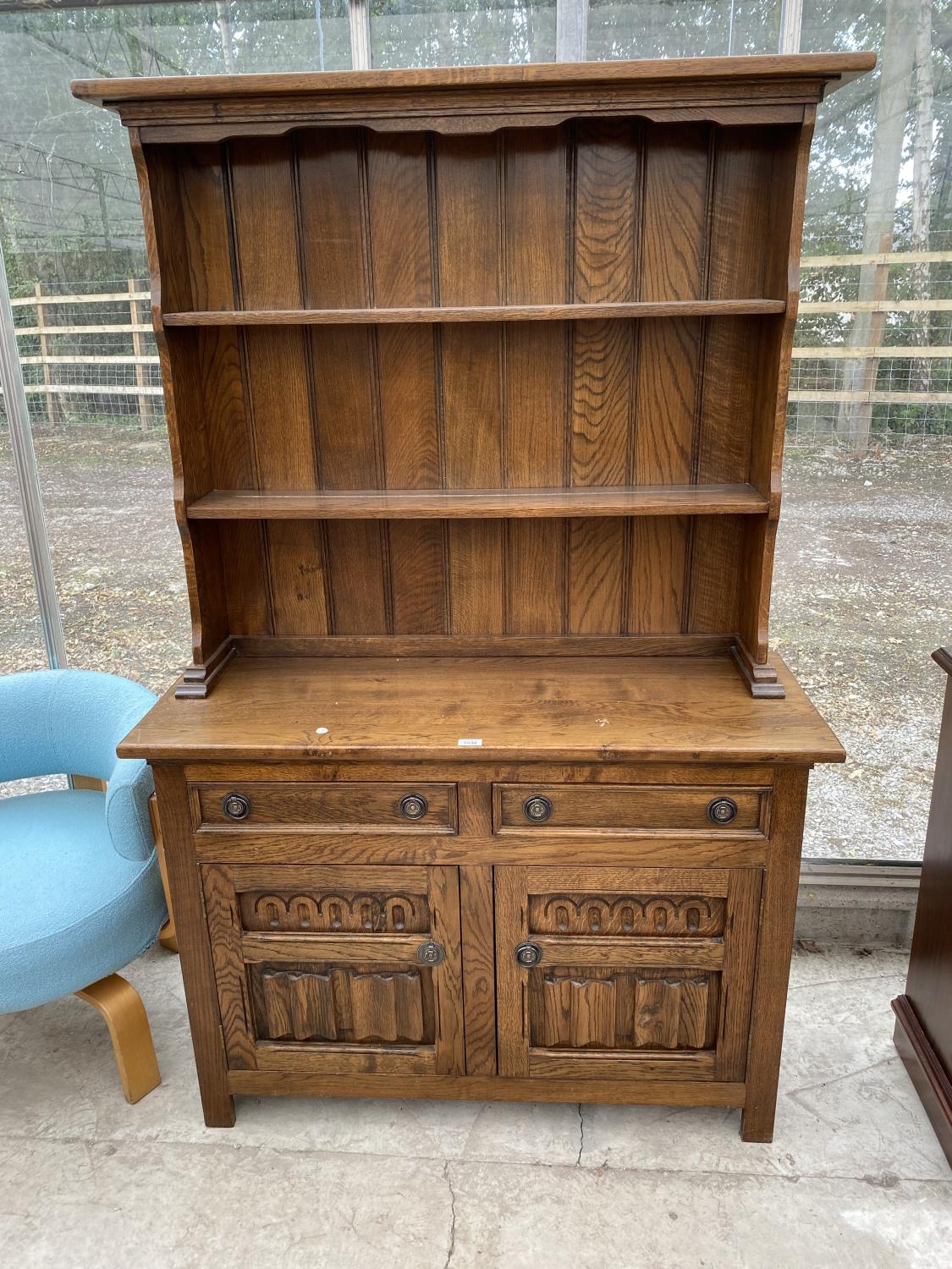 AN OAK WELSH DRESSER WITH TWO DOORS, TWO DRAWERS AND UPPER PLATE RACK
