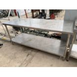 A LONG STAINLESS STEEL TABLE WITH LOWER SHELF