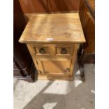 A PINE BEDSIDE CABINET WITH ONE DOOR AND ONE DRAWER