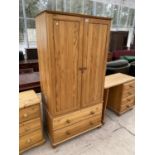 A PINE WARDROBE WITH TWO DOORS AND TWO DRAWERS AND A PINE DRESSING TABLE WITH FOUR DRAWERS