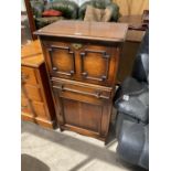 AN OAK COCKTAIL CABINET WITH FALL FRONT, OME DOOR AND ONE DRAWER