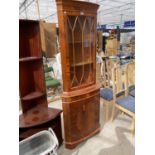 A YEW WOOD CORNER CABINET WITH LOWER DOOR AND UPPER GLAZED PANEL DOOR