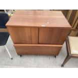 A TEAK CABINET ON CASTERS WITH TWO DOORS AND ONE DRAWER