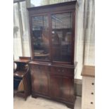 A MAHOGANY BOOKCASE CABINET WITH TWO DOORS, TWO DRAWERS AND TWO UPPER GLAZED DOORS