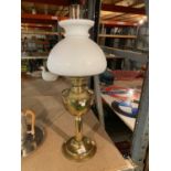 A BRASS OIL LAMP WITH WHITE GLASS SHADE