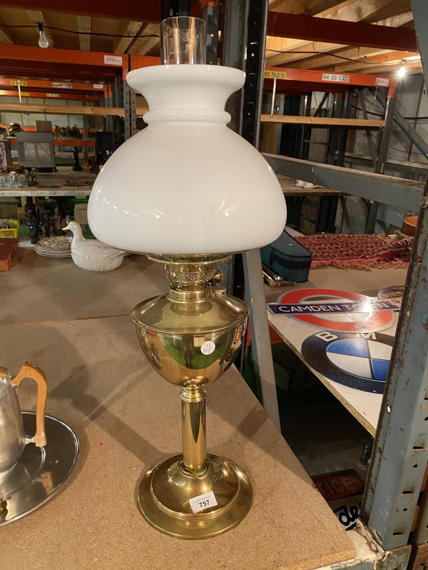 A BRASS OIL LAMP WITH WHITE GLASS SHADE