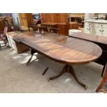 A MAHOGANY EXTENDING DINING TABLE ON TWIN PEDESTAL SUPPORTS