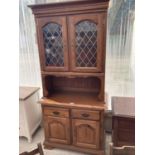 AN OAK DRESSER WITH TWO DOORS, TWO DRAWERS AND TWO UPPER LEAD GLAZED DOORS