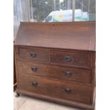 AN OAK BUREAU WITH FALL FRONT, TWO LONG AND TWO SHORT DRAWERS