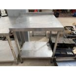 A STAINLESS STEEL TABLE WITH LOWER SHELF