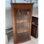 A YEW WOOD CORNER CUPBOARD WITH SINGLE GLAZED PANEL DOOR