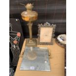 A BRASS OIL LAMP WITH AMBER GLASS SAHDE, MIRROR AND AN ORNATE PHOTO FRAME