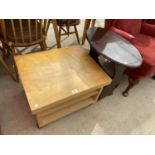 A BEECH COFFEE TABLE ON CASTERS AND A MAHOGANY MAGAZINE RACK TABLE