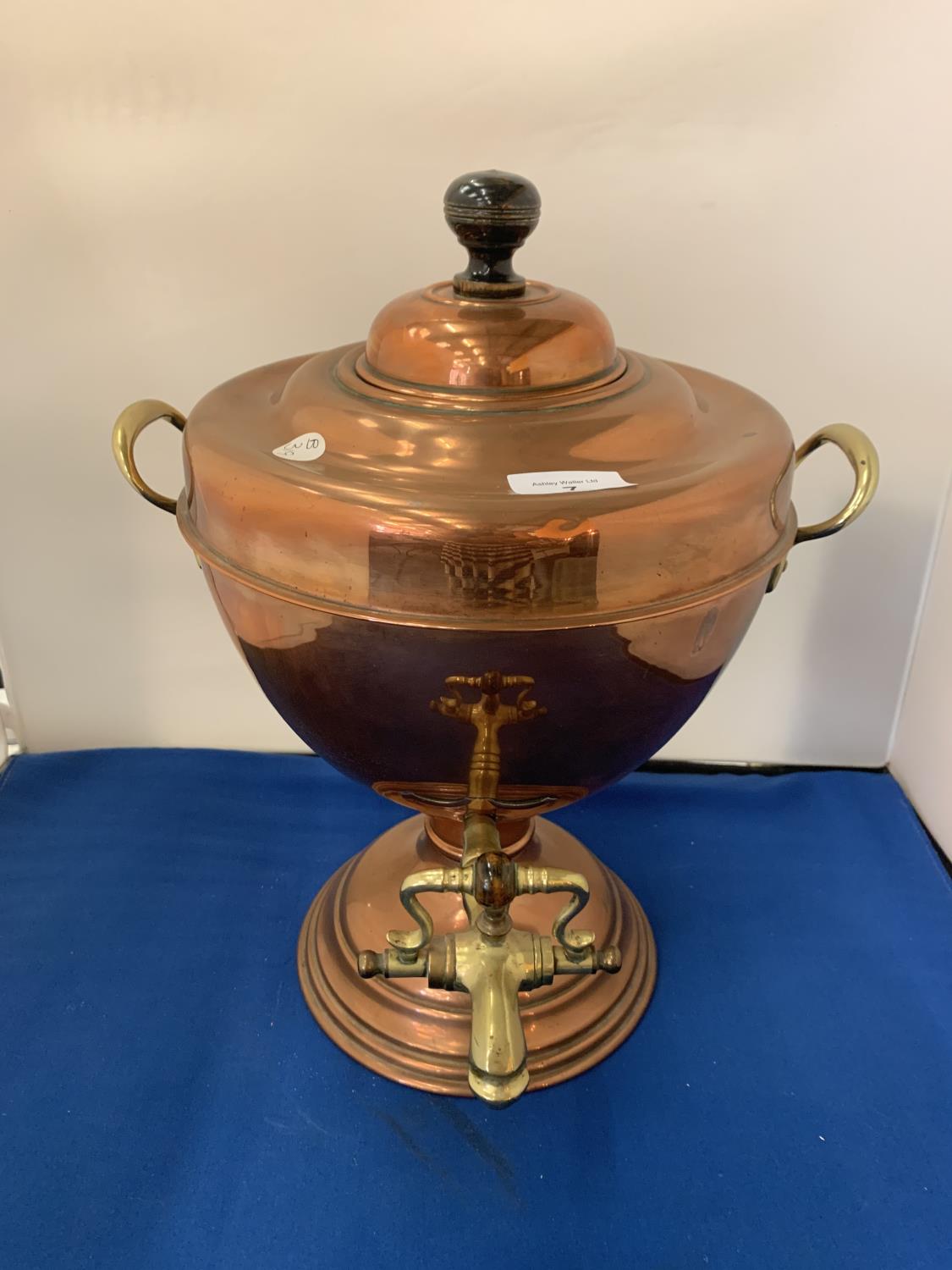 A BRASS AND COPPER TWIN HANDLED URN