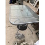 A RECTANGULAR GLASS TOPPED GARDEN TABLE AND A PARASOL BASE