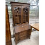 AN ARTS AND CRAFTS STYLE OAK BUREAU BOOKCASE WITH FALL FRONT, THREE DRAWERS AND TWO UPPER LEAD