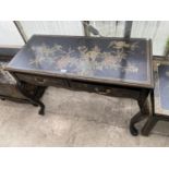 AN ORIENTAL JAPANNED SIDE TABLE WITH ELABORATE DECORATION AND TWO DRAWERS WITH BRASS HANDLES