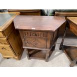 A CARVED OAK CANTED HALL CUPBOARD WITH ONE DOOR AND ONE DRAWER