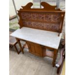 A SATINWOOD WASHSTAND WITH ONE DOOR, TWO DRAWERS, MARBLE TOP AND SPLASHBACK WITH ELABORATE TILES