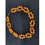 AN AMBER COLOURED BEADS NECKLACE