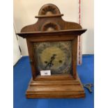 AN OAK CASED CHIMING MANTLE CLOCK WITH KEY