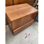 A TEAK CABINET ON CASTERS WITH TWO DOORS AND ONE DRAWER