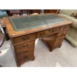 A MAHOGANY TWIN PEDESTAL DESK WITH NINE DRAWERS AND GREEN LEATHER WRITING SURFACE
