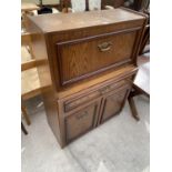 AN OAK EFFECT BUREAU WITH FALL FRONT, TWO DOORS AND ONE DRAWER AND A SQUARE OAK SIDE TABLE