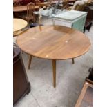 AN ERCOL CIRCULAR DROP LEAF ELM DINING TABLE