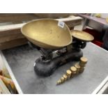 A SET OF BOOTS BLACK AND BRASS KITCHEN SCALES WITH EIGHT GRADUATED CYLINDRICAL BRASS WEIGHTS