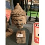 AN ANTIQUE STYLE STONE BUDDHA HEAD ON A STEEL PLINTH