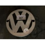 A SMALL CIRCULAR CAST VW SIGN