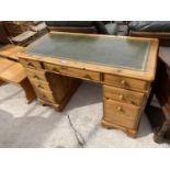 A DUCAL PINE TWIN PEDESTAL DESK WITH EIGHT DRAWERS AND GREEN LEATHER WRITING SURFACE