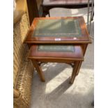 A NEST OF TWO YEW WOOD TABLES WITH GREEN LEATHER TOPS