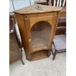 A PINE CORNER CABINET WITH SINGLE GLAZED DOOR