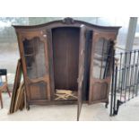 AN OAK CABINET ON CABRIOLE SUPPORTS WITH THREE GLAZED PANEL DOORS