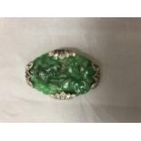 A WHITE METAL AND JADE BROOCH