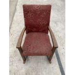A VINTAGE CHILDRENS ROCKING CHAIR WITH OAK FRAME AND UPHOLSTERED SEAT AND BACK