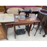 A SINGER TREADLE SEWING MACHINE IN A MAHOGANY CABINET