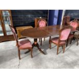 A MAHOGANY EXTENDING DINING TABLE ON TWIN PEDESTAL SUPPORTS AND FOUR DINING CHAIRS