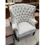 A BUTTON AND WING BACK ARMCHAIR