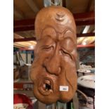 A CARVED WOODEN FACE PLAQUE