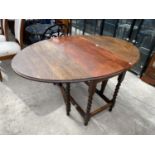 AN OAK DROP LEAF DINING TABLE ON BARLEY TWIST SUPPORTS