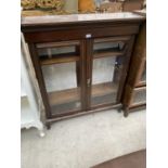 A MAHOGANY CABINET ON CABRIOLE SUPPORTS WITH TWO GLAZED DOORS AND INNER SHELVING